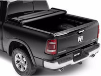 Tri Fold soft tonneau cover for Ram 1500 Laramie by Lund Motion Products Inc, shown folded on the truck bed.