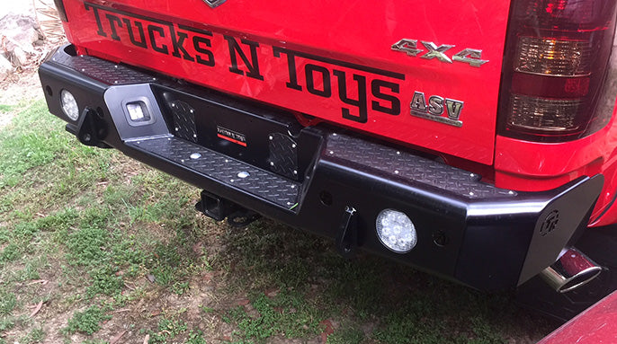 TrailReady rear bumper for RAM 2500 and 3500 trucks, featuring a rugged metal design and mounting points for towing accessories.
